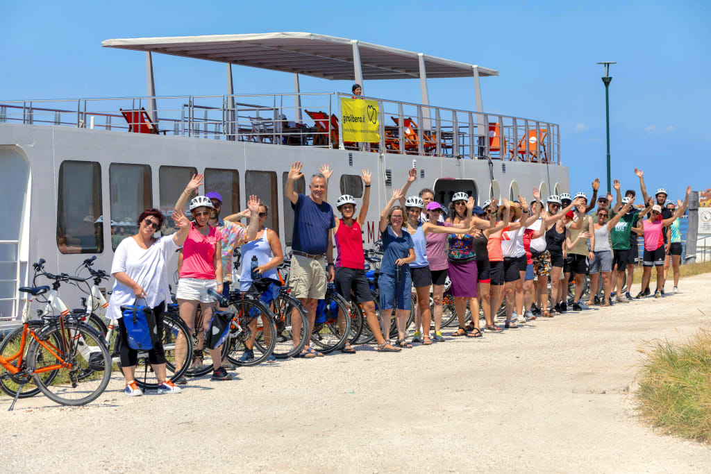 Gruppo numeroso di cicloturisti pronti alla partenza in posa davanti alla barca "Ave Maria", viaggi bici e barca "Girolibero"