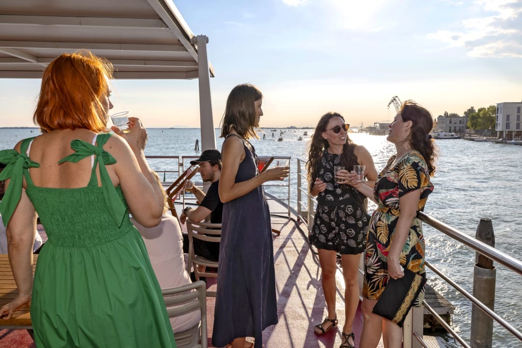 Persone che chiacchierano sul ponte della nave durante il tramonto, Venezia.