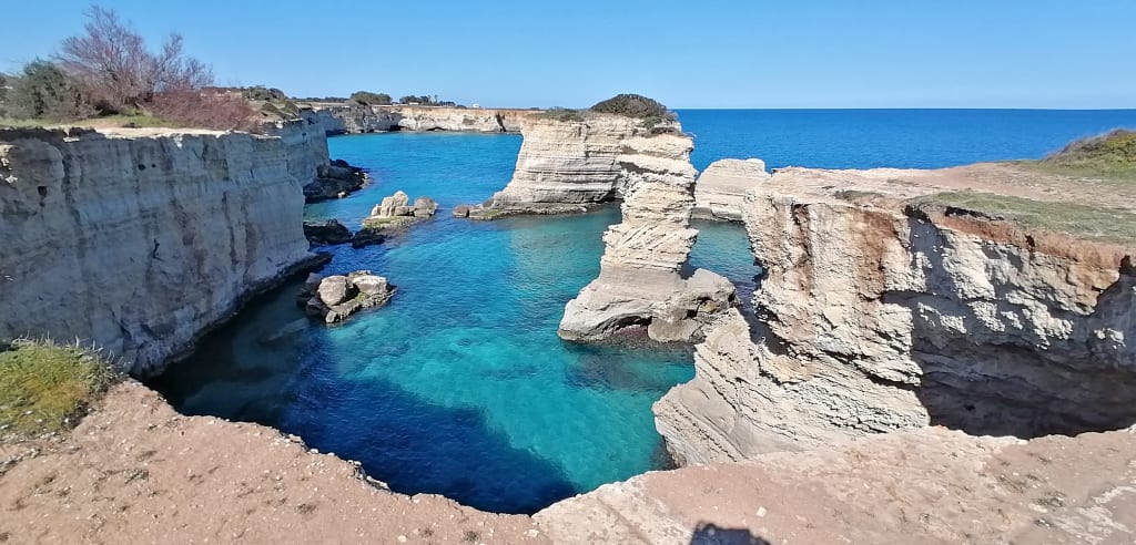 Formazioni rocciose costiere e mare blu cristallino, Salento.
