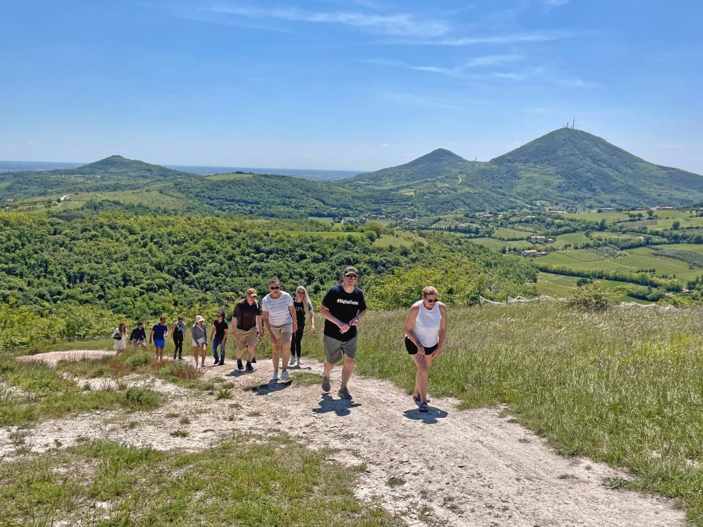 Gruppo di viaggiatori in cammino sui Colli Euganei, trekking guidato in Veneto nella natura