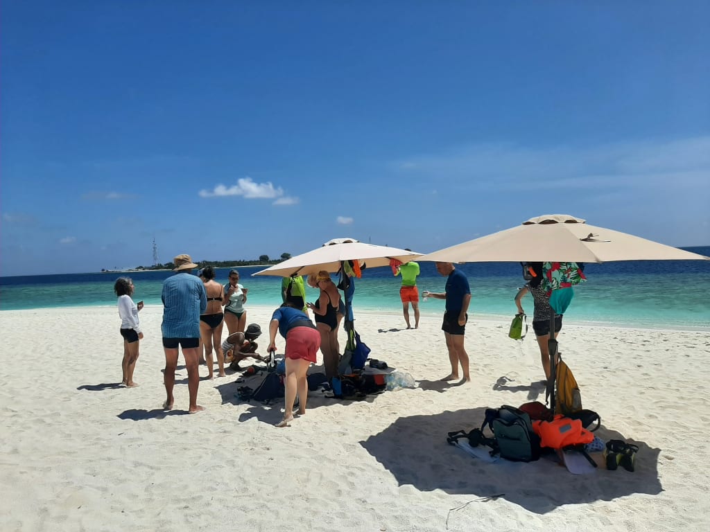 Escursione organizzata su spiaggia con ombrelloni, Maldive viaggio di gruppo tra mare e relax