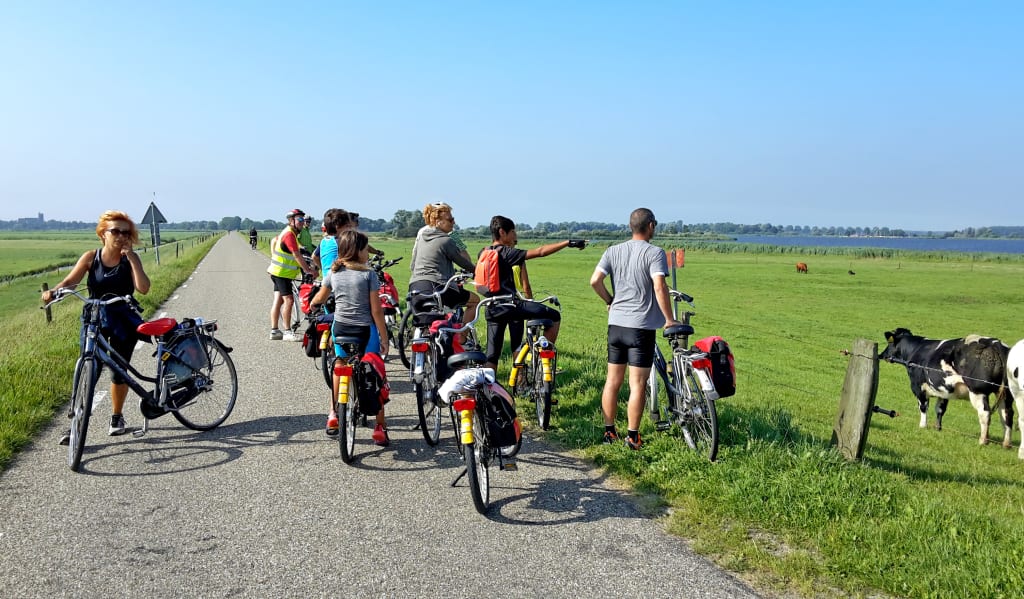 Gruppo di ciclisti in viaggio con Girolibero con bambini in una sosta panoramica in campagna olandese.