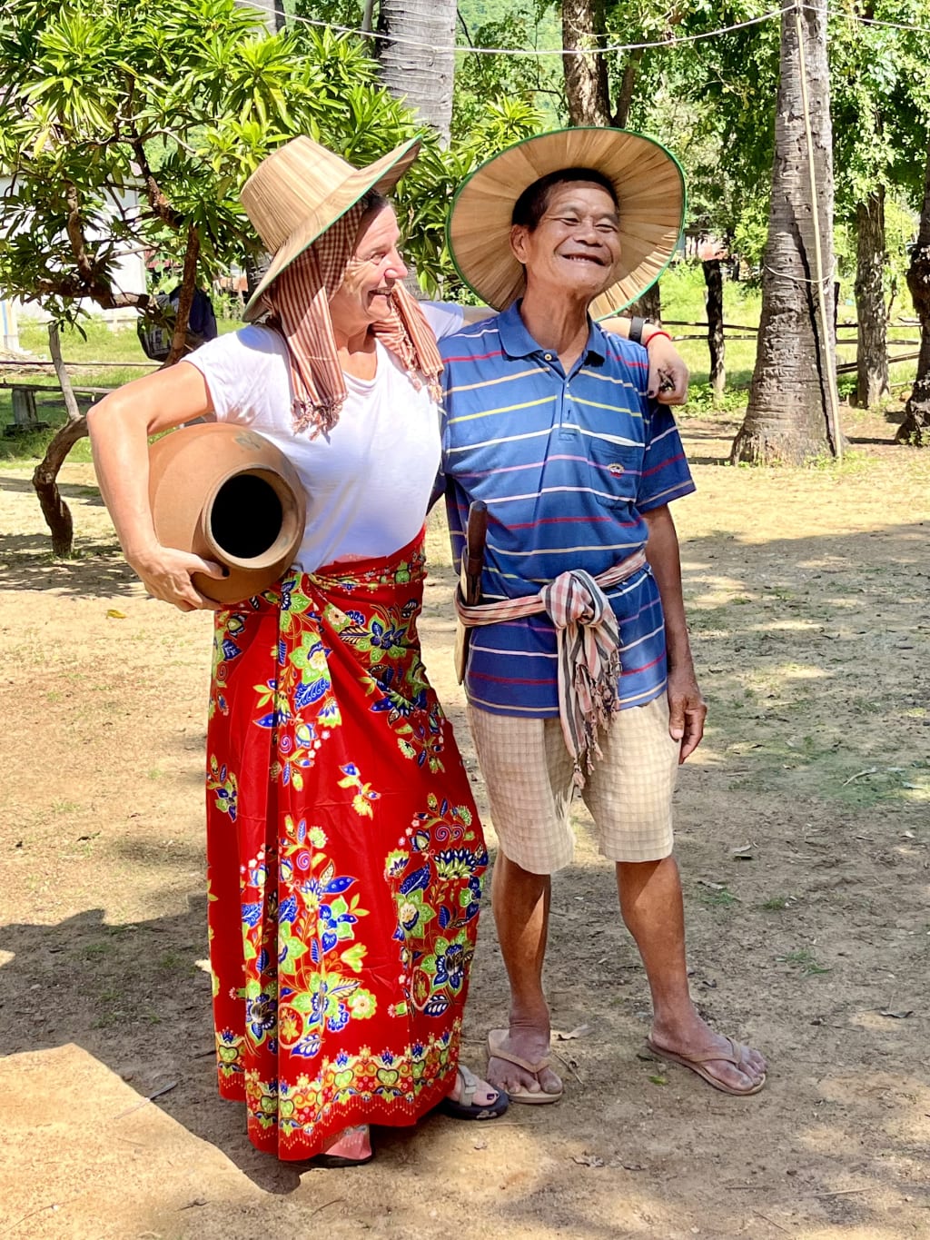 Esperienza rurale: abiti tradizionali khmer e brocca d’argilla in un villaggio cambogiano