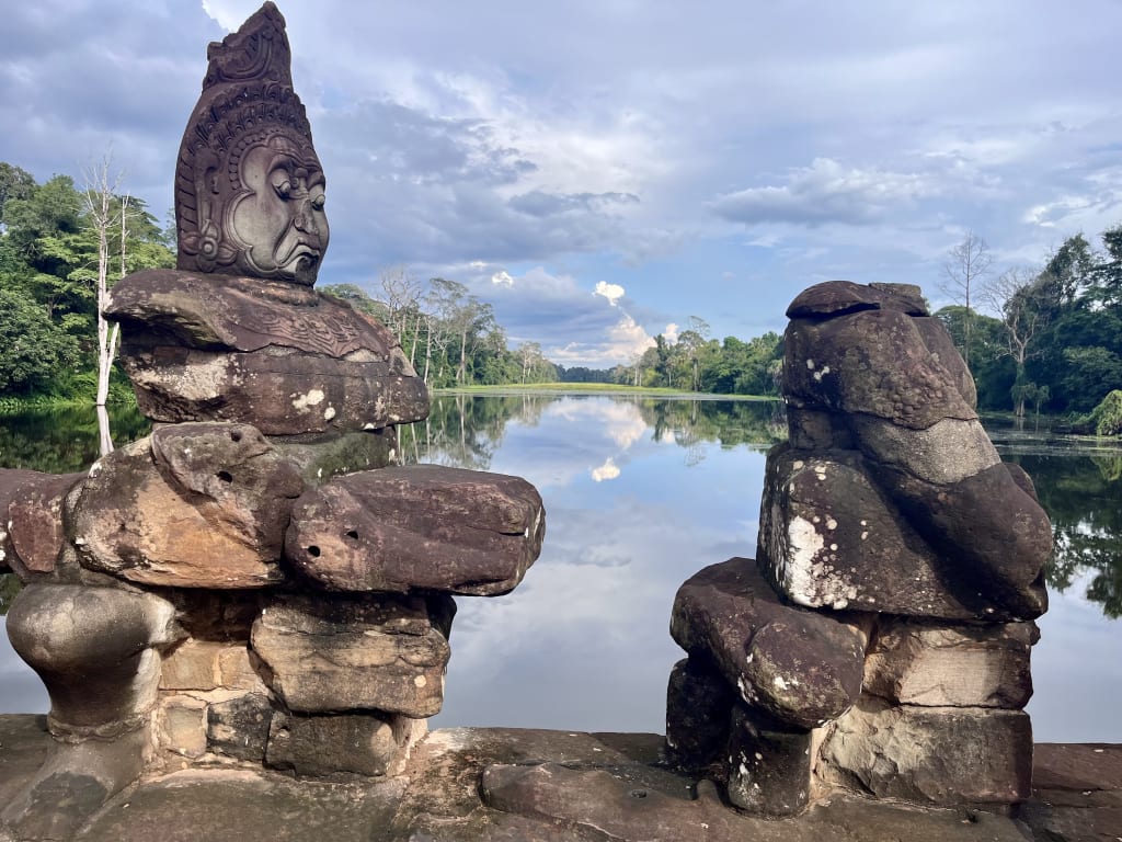Sculture di guardiani naga sul ponte del South Gate di Angkor Thom che attraversa il fossato