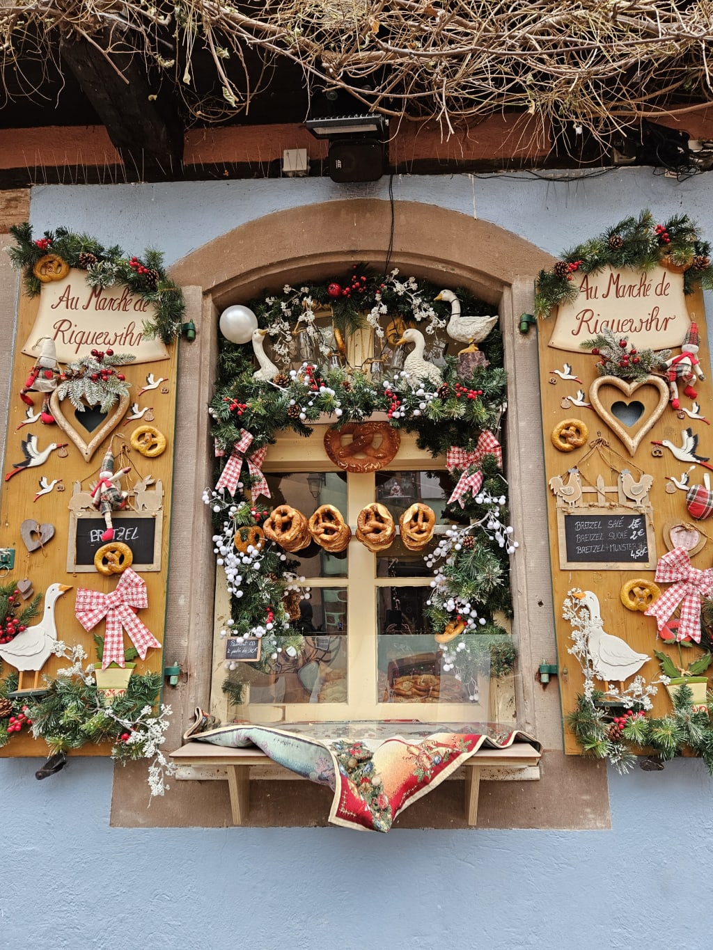 Vetrina decorata con dolci tipici e ghirlande a Kaysersberg, Alsazia.