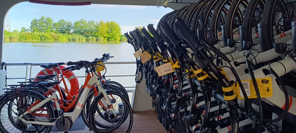 Biciclette parcheggiate sul ponte della chiatta in navigazione fluviale, viaggi organizzati in bici e barca "Girolibero"