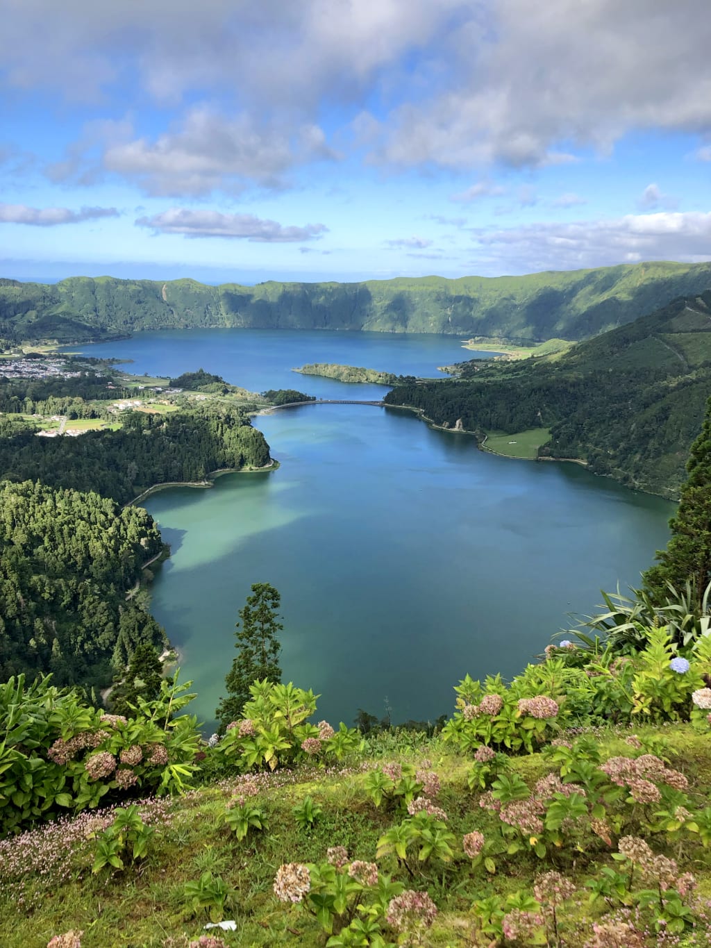 Paesaggio verde con vista su un grande lago vulcanico circondato da colline nelle Azzorre.