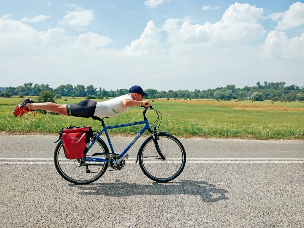 Ciclista solitario su una strada panoramica nella regione dei Laghi Masuri, Polonia.