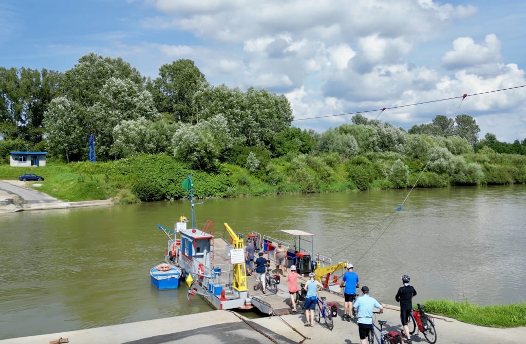 Ciclisti in viaggio con Girolibero attraversano con il traghetto il fiume Vistola, Polonia.