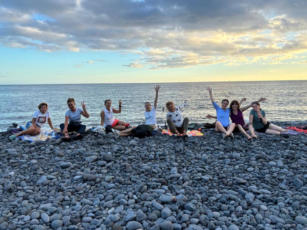 Gruppo che cena in riva al mare su una spiaggia di ciottoli, Madeira, Portogallo.