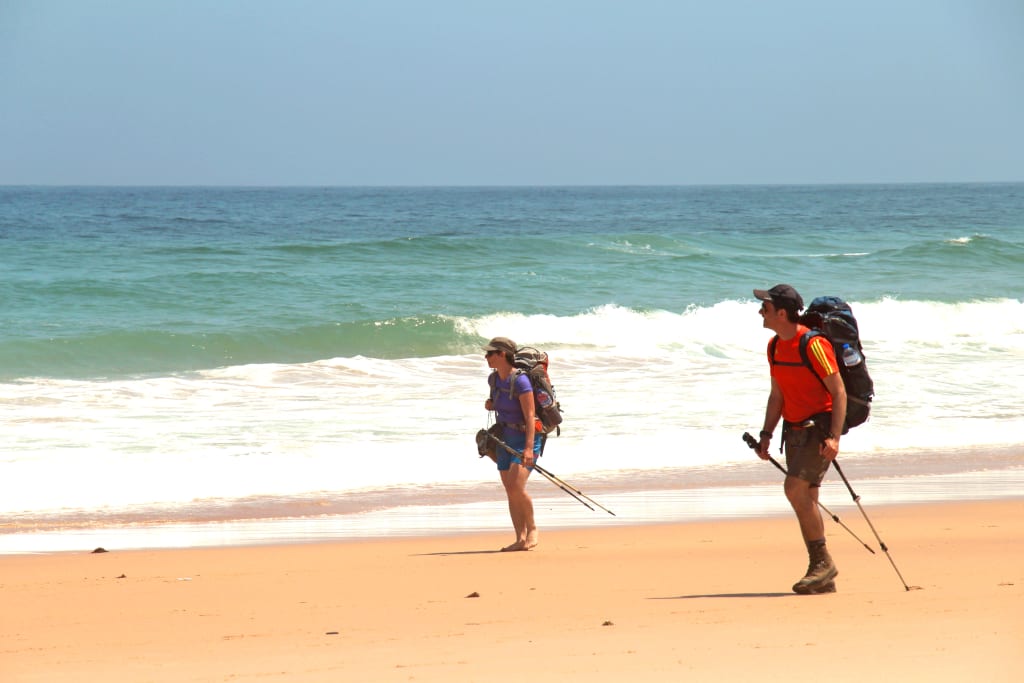 Escursionisti camminano in riva all'oceano lungo la Rota Vicentina, Portogallo