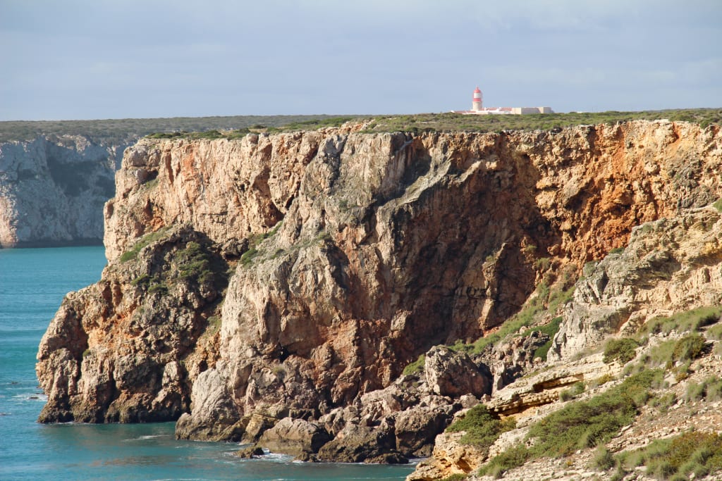 Scogliera alta e ripida sulla costa dell'Algarve, Portogallo.