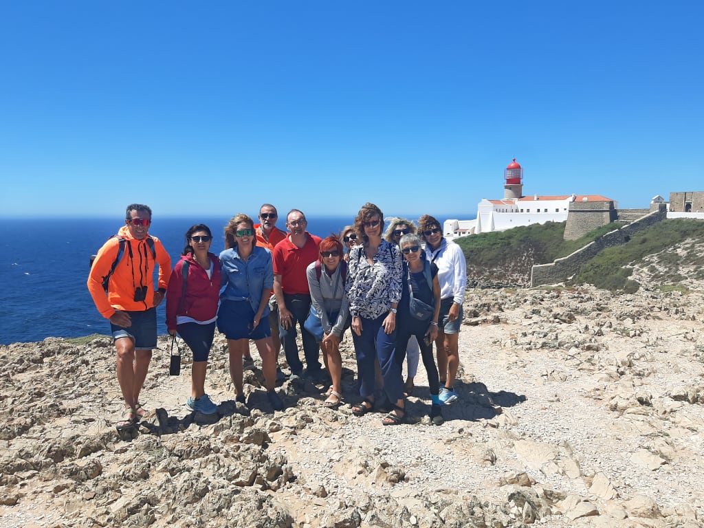 Gruppo di persone in posa tra un panorama lungo le scogliere della Rota Vicentina, Portogallo, vacanze a piedi "Girolibero"