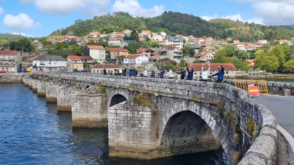 Cicloturisti sul ponte di Pontevedra, storico borgo del nord del Portogallo lungo il Cammino Portoghese