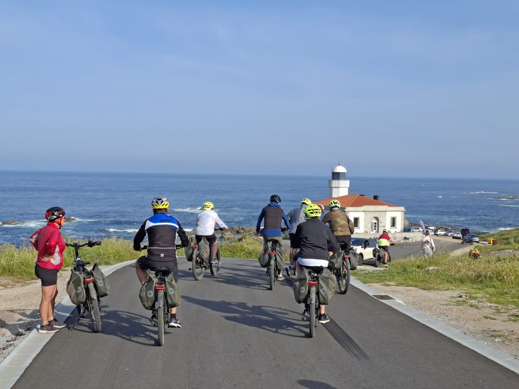 Ciclisti lungo la strada costiera dell’Atlantico nel nord del Portogallo durante un viaggio di cicloturismo tra oceano e scogliere