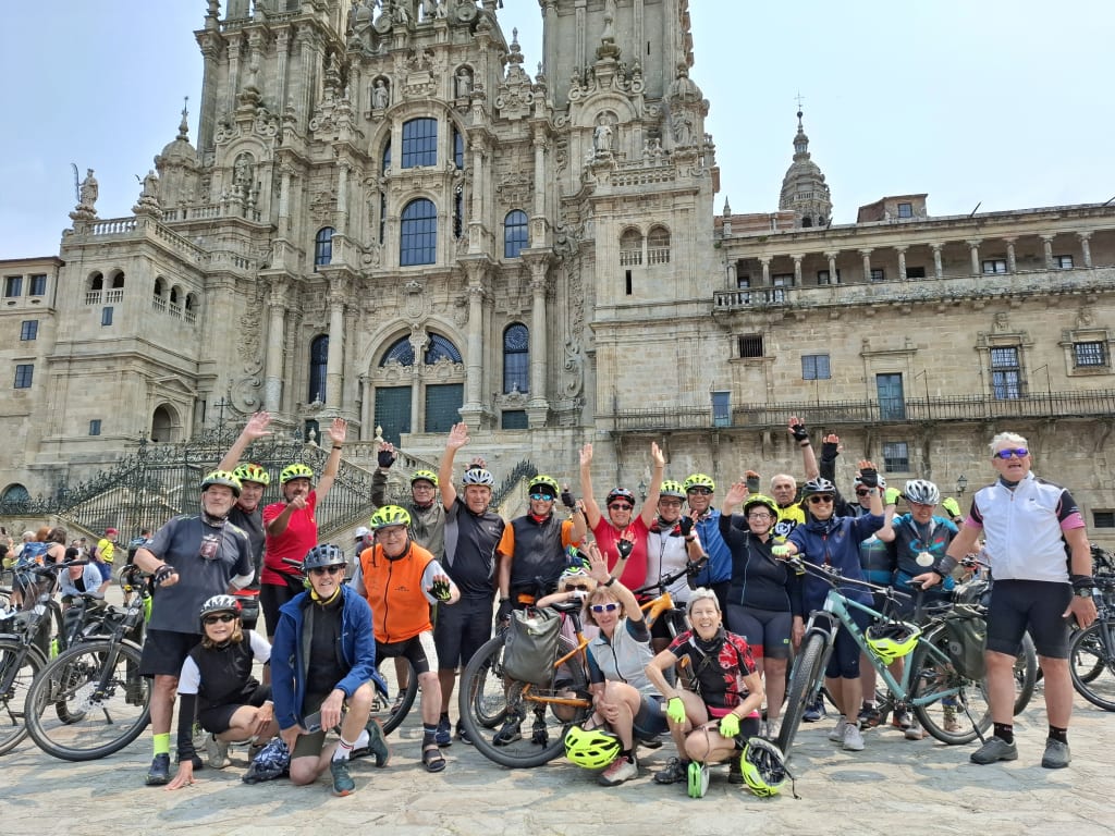 Gruppo di cicloturisti in Plaza del Obradoiro davanti alla Cattedrale di Santiago de Compostela, meta finale del Cammino