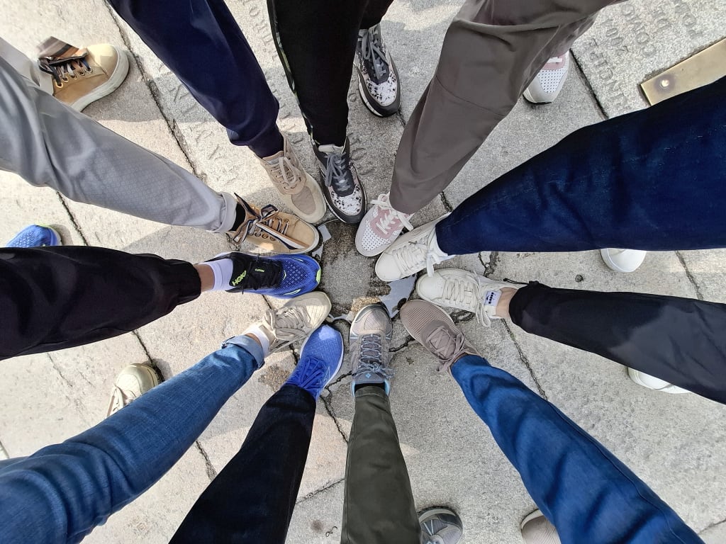 Cerchio di piedi dei partecipanti a un viaggio di gruppo in bici, momento di condivisione tra cicloturisti durante il tour
