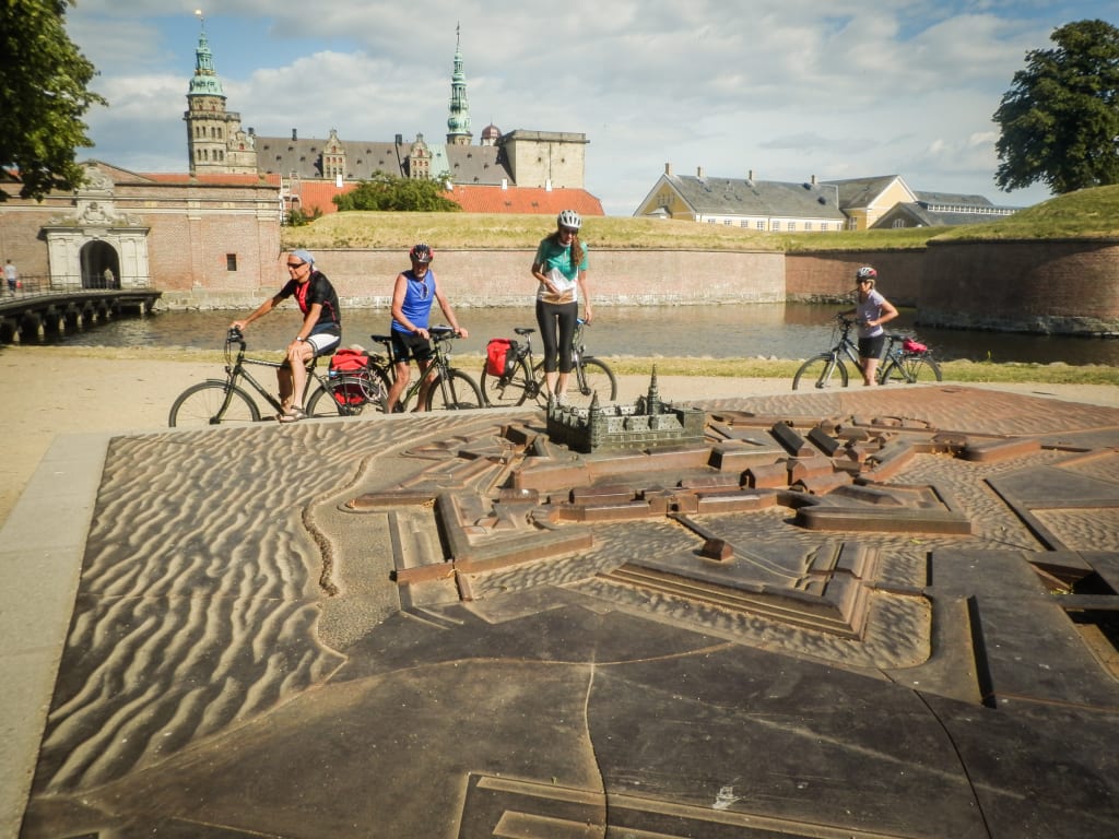 Gruppo di ciclisti in pausa davanti al Kronborgslot Castle, tra Danimarca e Svezia
