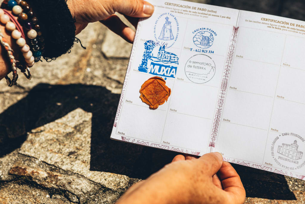 Primo piano di un passaporto del pellegrino con timbri delle tappe completate lungo il Cammino di Santiago.