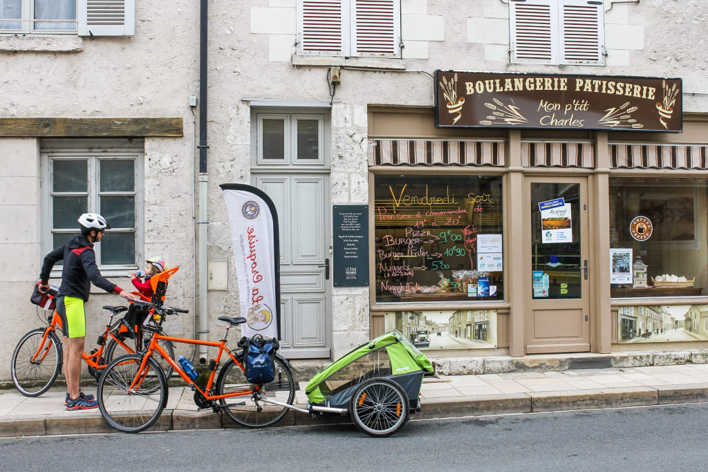 Radfahrer bei einer Pause vor einem Geschäft in Chinon, Frankreich.