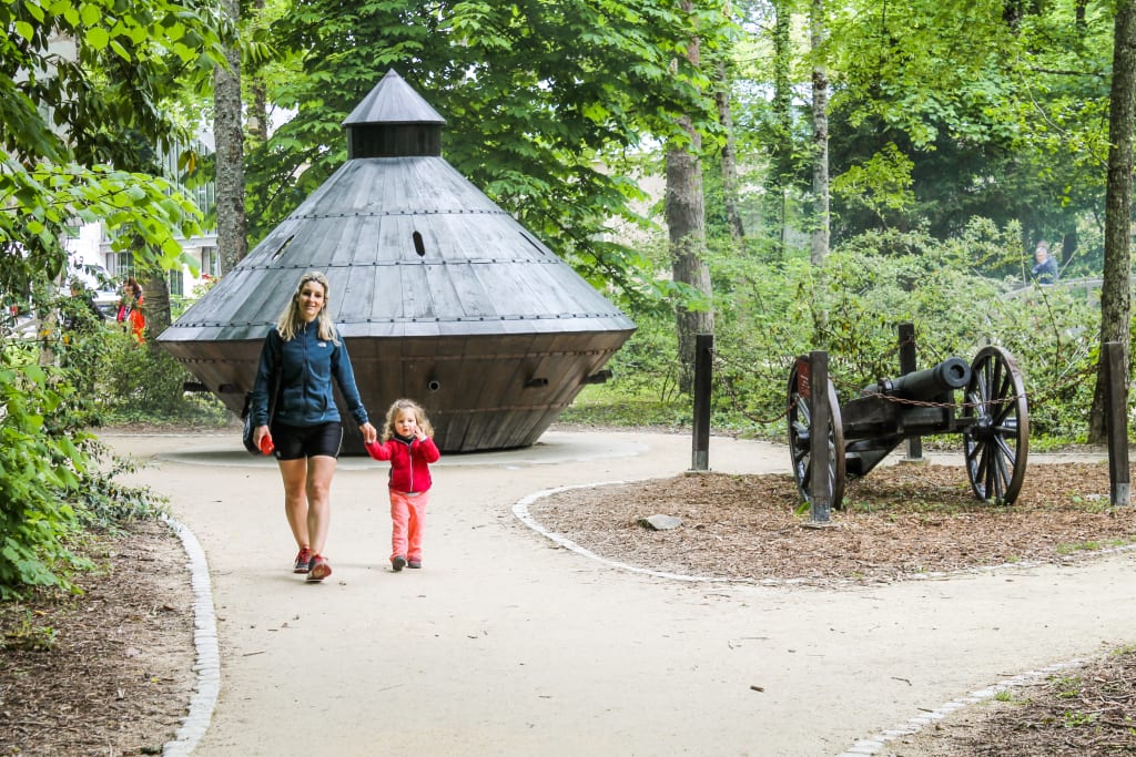 Mutter und Tochter gehen Hand in Hand durch einen Park im Grünen des Loiretals.