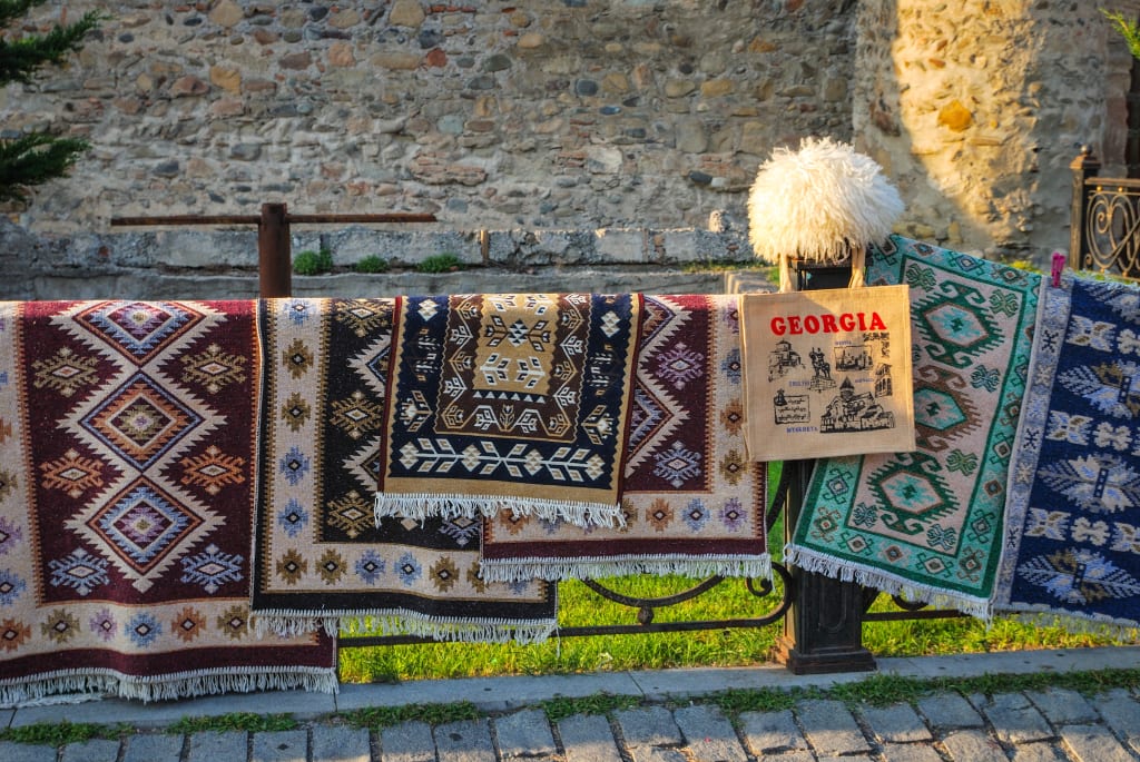 Tappeti e kilim tradizionali georgiani esposti in un mercato all'aperto.