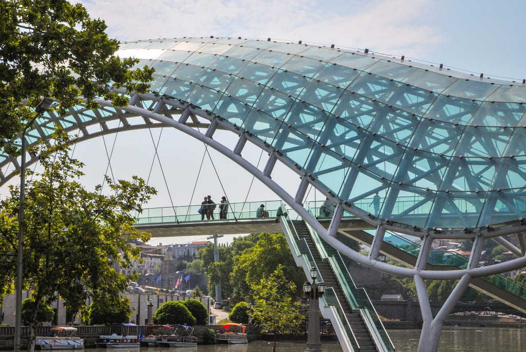 Il Ponte della Pace a Tbilisi, struttura moderna in vetro e acciaio sul fiume Kura.