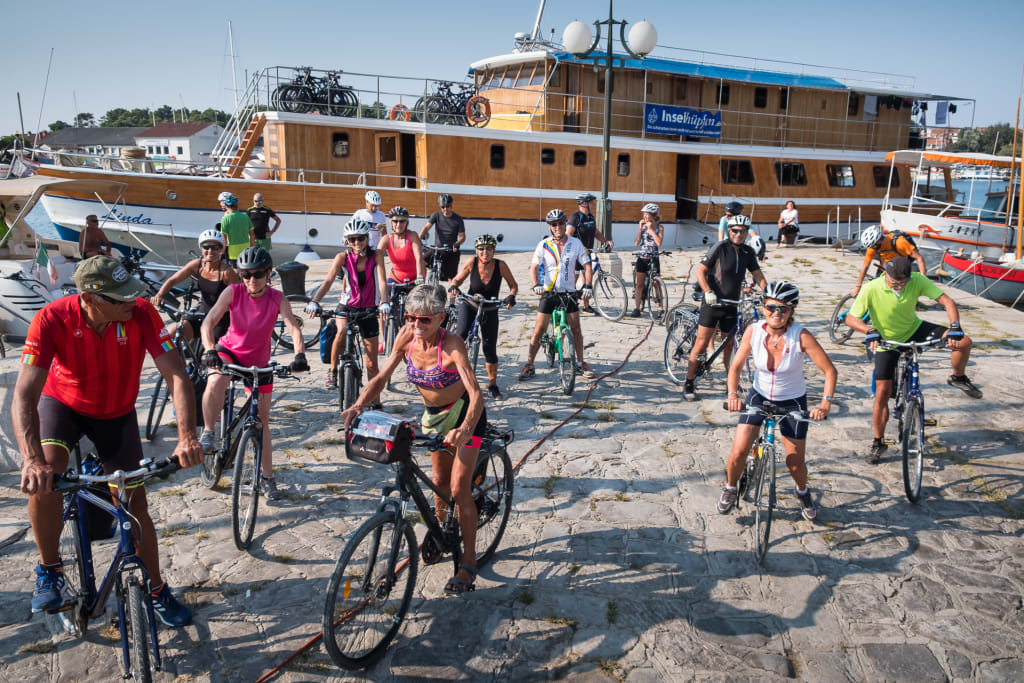 Gruppe von Radfahrern, die sich vor einem Gebäude zur Abfahrt vorbereiten, Radtour, Kroatien.