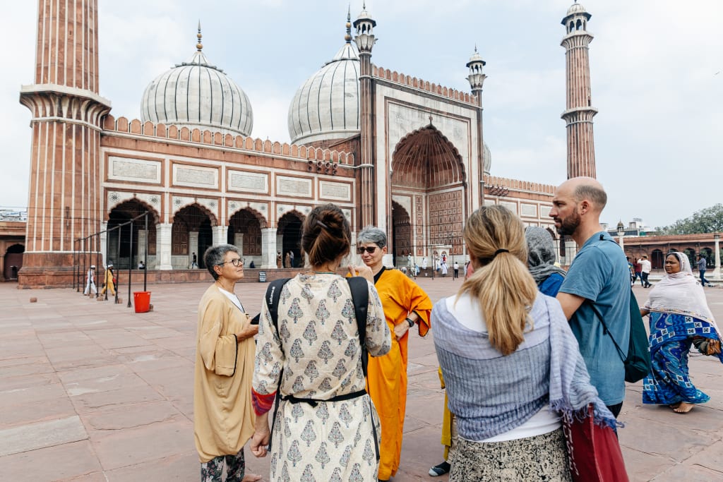 Viaggiatori davanti alla Jama Masjid di Delhi, storica moschea moghul nel centro storico della capitale dell’India