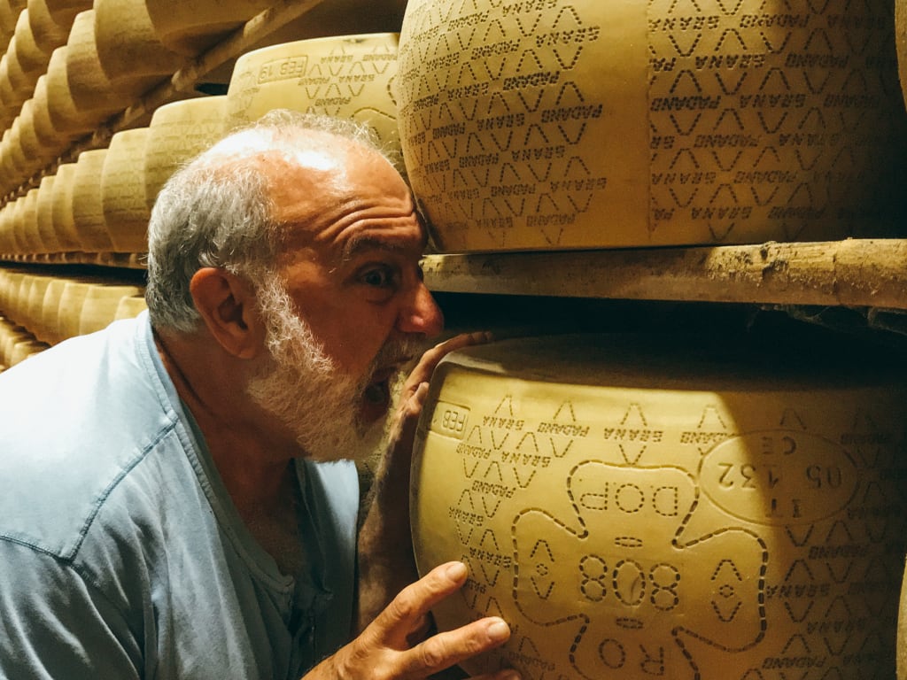 Visitatori che annusano le forme di Parmigiano Reggiano durante una degustazione in Emilia-Romagna, Italia.