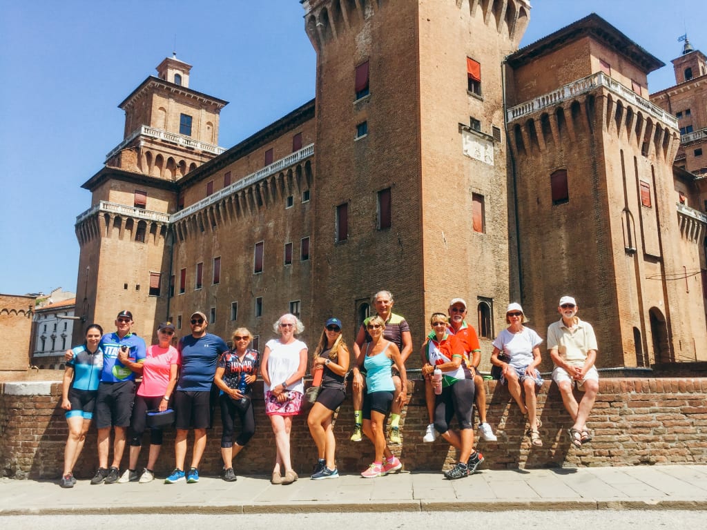 Gruppe, die mit Girolibero unterwegs ist, vor einer mittelalterlichen Burg in Italien