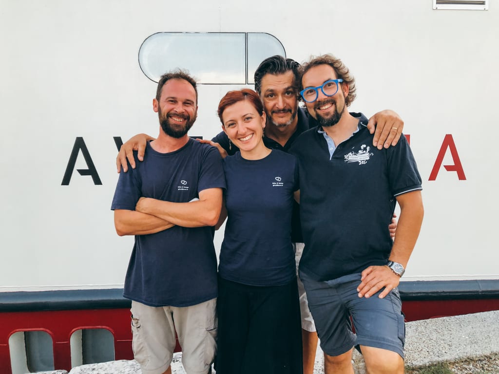 Eine Gruppe von Freunden posiert für ein Foto vor dem Boot Ave Maria