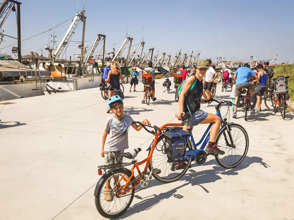 Tandem "Girolibero", ciclista con bambino tra un paesaggio caratteristico nelle Valli di Comacchio, nel delta del Po.
