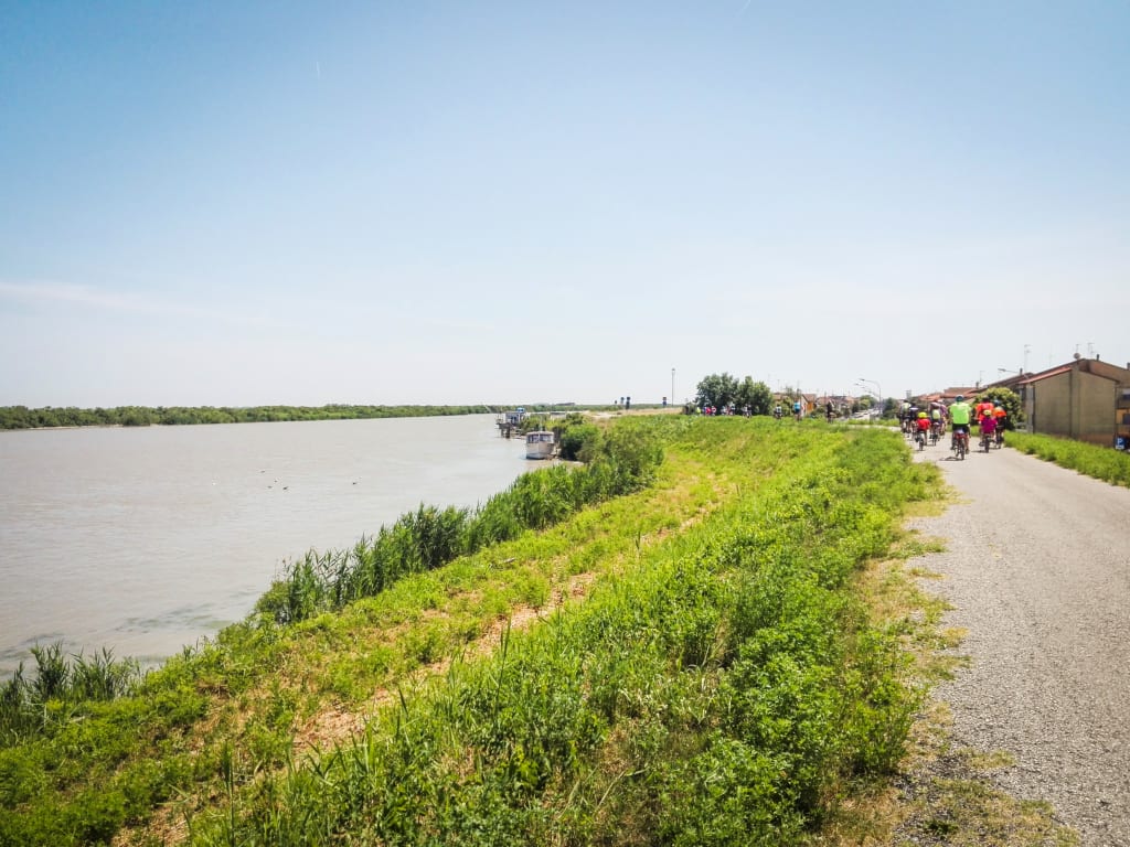 Percorso ciclabile tra campi e canali nel Parco del Delta del Po.