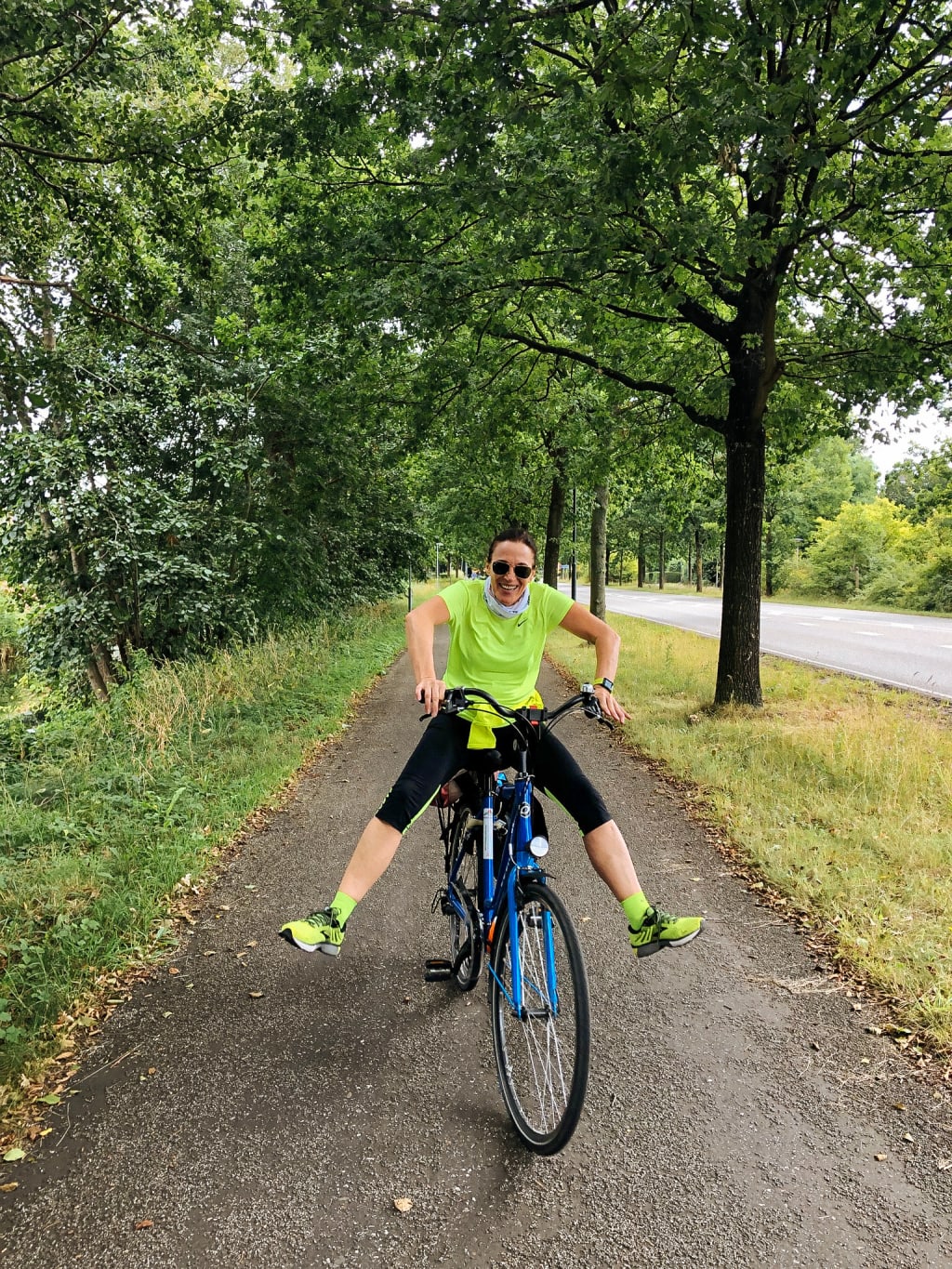 Ciclista in un parco verde lungo una pista ciclabile, viaggiare in bici