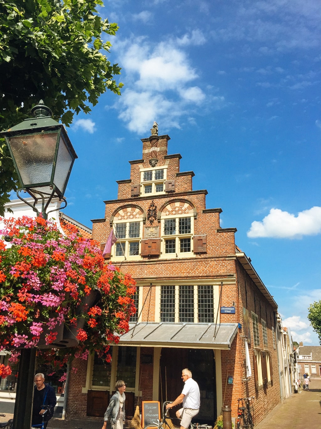 Edificio storico con facciata a gradoni e fiori a Naarden, Olanda