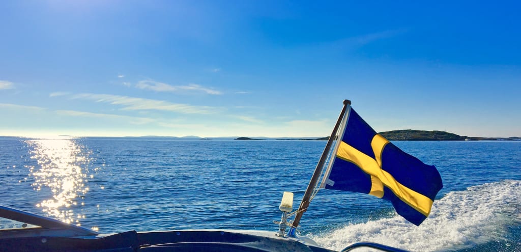 Bandiera della Svezia che sventola su una barca nel Mar Baltico.