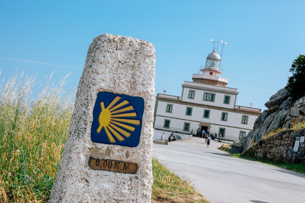 Mojon del kilometro zero con il faro di Finisterre, Galizia