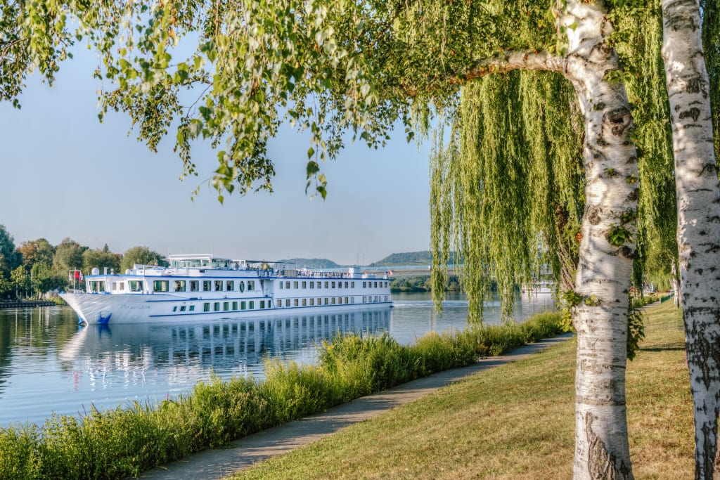 River cruise ship docked along a Dutch canal, bike and barge holiday in the Netherlands.