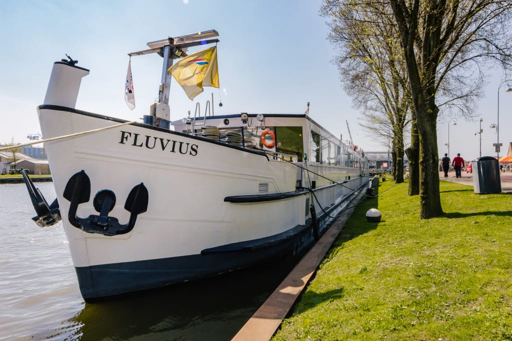 Barca da crociera "Fluvius" ormeggiata lungo un canale a Bruges, Belgio.