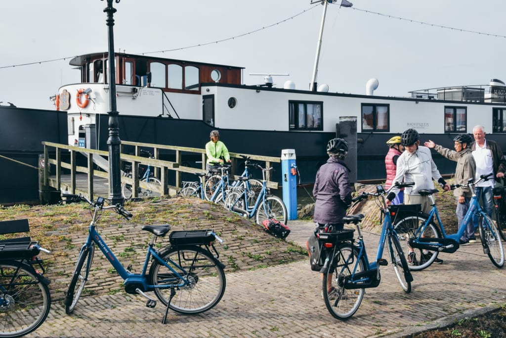 Ciclisti che scendono dalla "Magnifique IV" con bici in primo piano