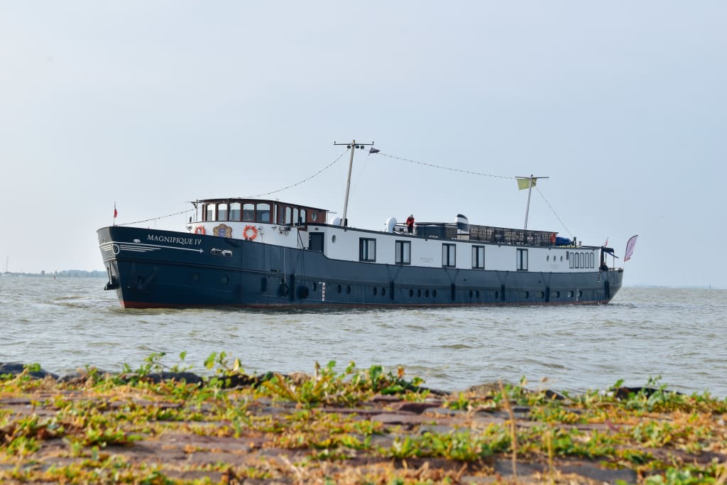 Chiatta fluviale "Magnifique IV" in navigazione lungo un canale olandese