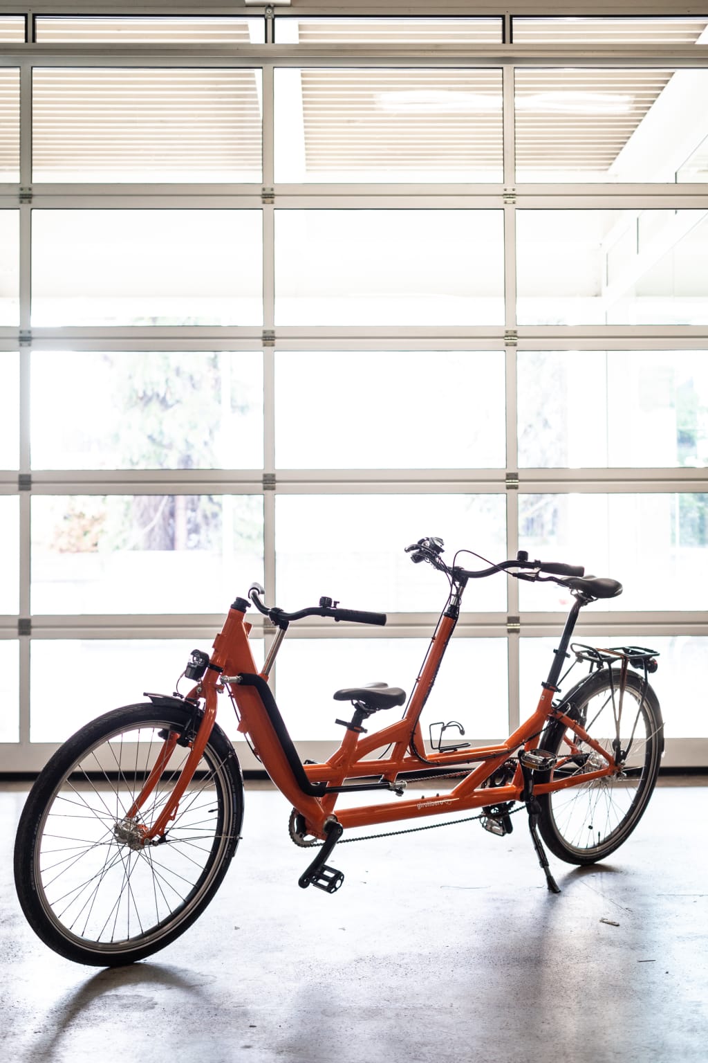 Orange tandem bike parked inside the Girolibero workshop