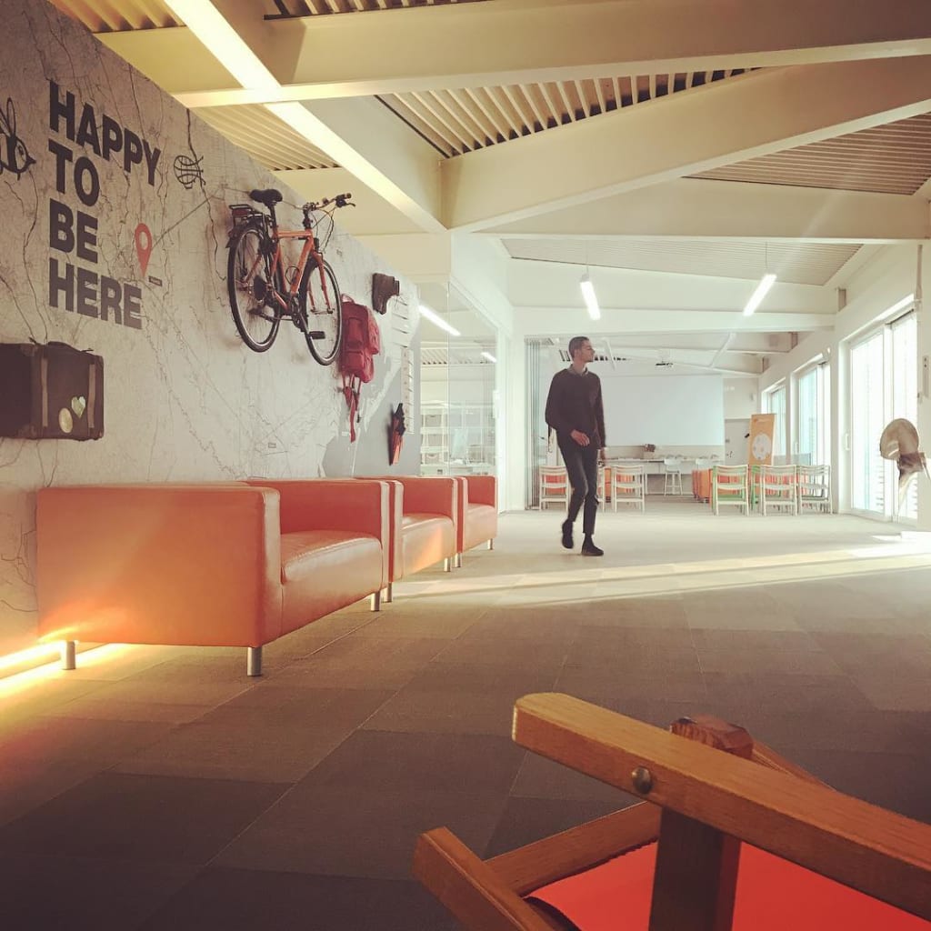 Interno della sede "Girolibero" a Vicenza, bici appese, valigia viaggio e slogan sul muro