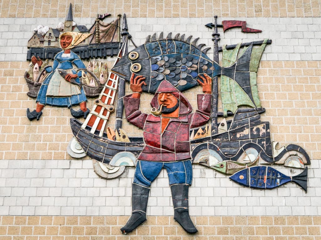 Decorazione con piastrelle colorate su un muro a Bruges che richiama la pesca, barca, pescatore, pescivendola