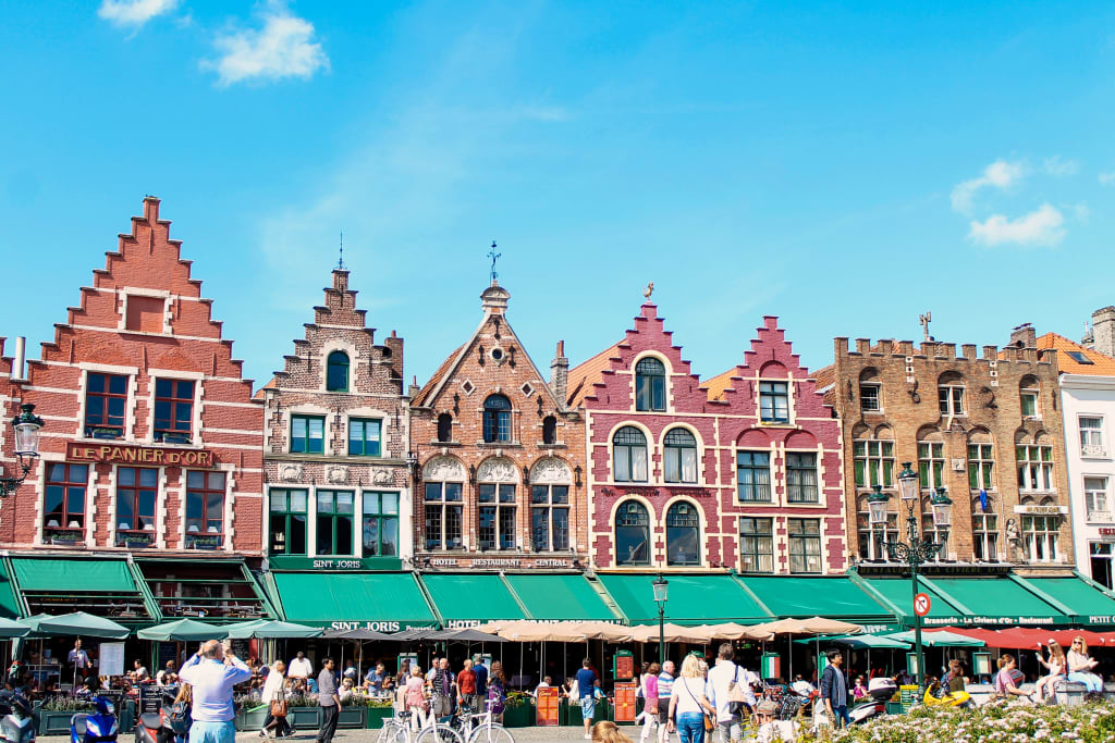 Storiche case colorate con tetti a gradoni nella piazza principale di Bruges, Fiandre