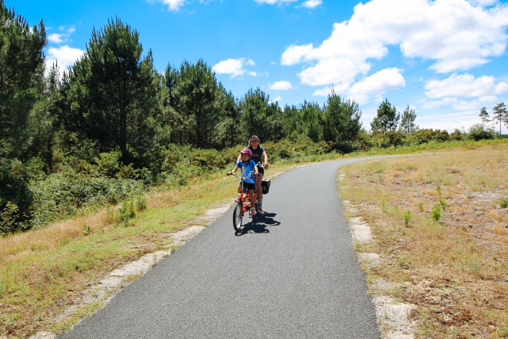 Turista in bicicletta su un sentiero boschivo vicino alla spiaggia, Francia