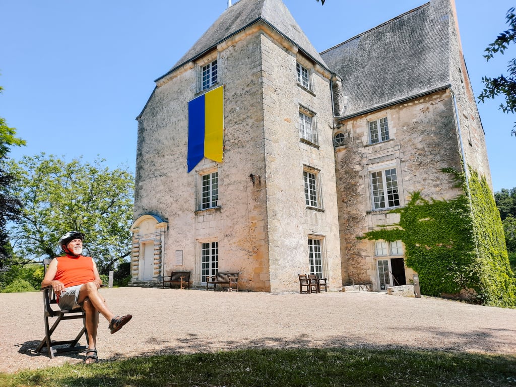 Viaggiatore in pausa relax seduto davanti a un edificio storico in pietra a Loches, Francia.