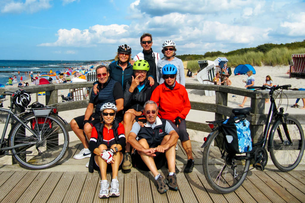 Gruppo di ciclisti si ferma per una pausa su una passerella con vista sul mare Baltico, vacanze di gruppo in bici "Girolibero"