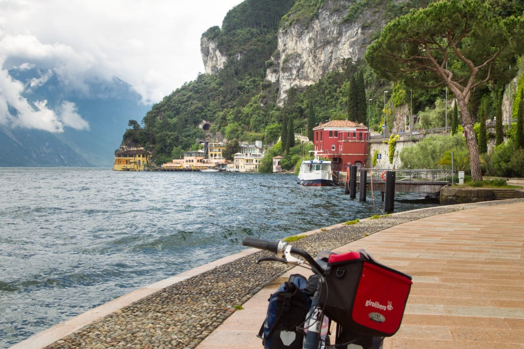 Bikes with bags parked on a wooden walkway near Lake Garda